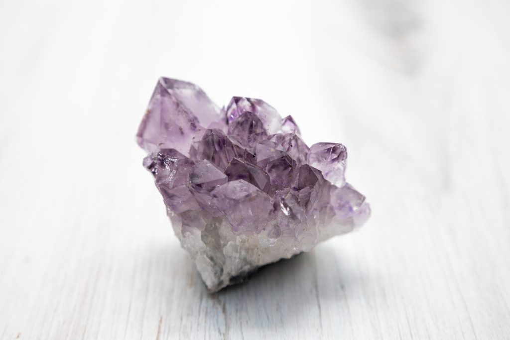 Amethyst crystal on white table