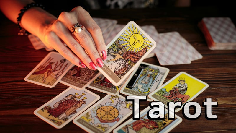 tarot cards on table with fortune teller hand